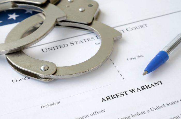 Bench warrant search fotolia chained handcuffs sergey hands th men background How to clear a bench warrant without going to jail